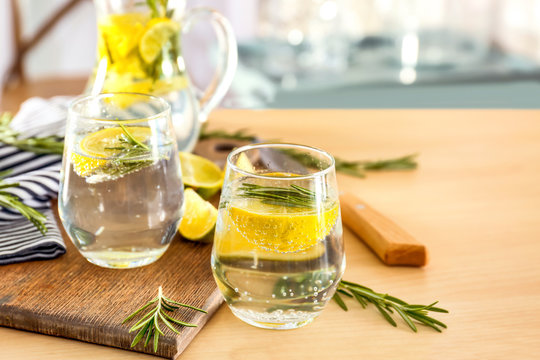 Glasses of fresh lemonade with rosemary on table