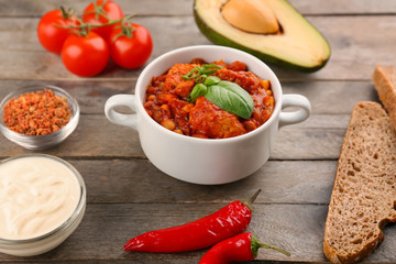 Casserole with delicious chili turkey on wooden table