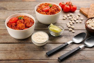 Two bowls with delicious chili turkey on wooden table