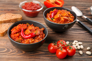 Two bowls with delicious chili turkey on wooden table