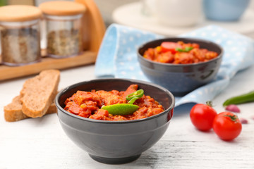 Bowl with delicious chili turkey on wooden table