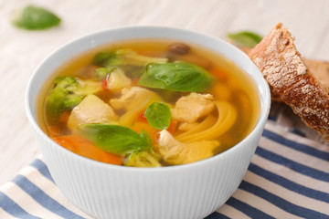 Bowl with delicious turkey soup and bread on table