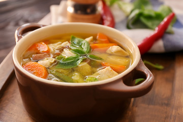 Casserole with delicious turkey soup on wooden board