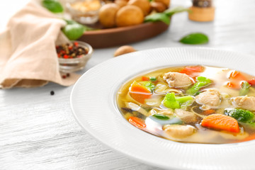 Plate with delicious turkey soup on wooden background, close up
