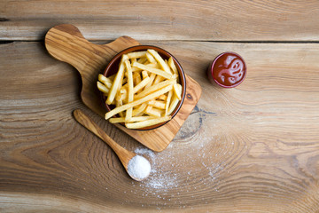 Delicious fries on wooden board