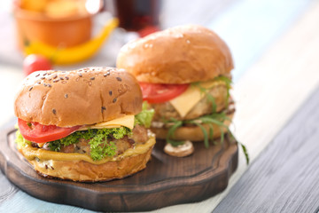 Two turkey burgers on wooden board, close up