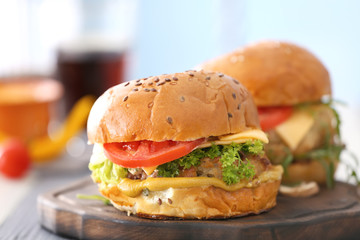 Two turkey burgers on wooden board, close up