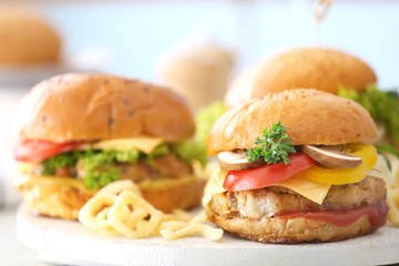 Composition of three tasty turkey burgers on wooden board