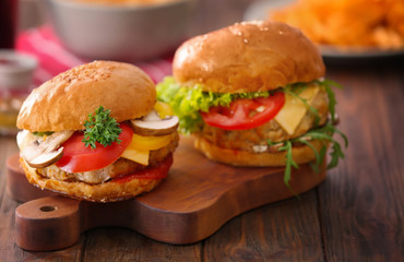 Two turkey burgers on wooden board, close up