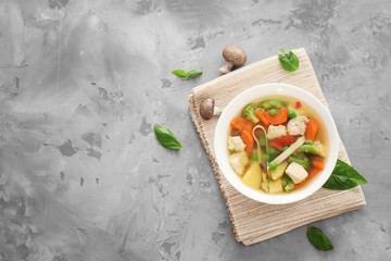 Bowl with delicious turkey soup on grey background