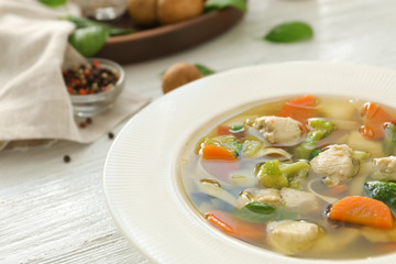 Plate with delicious turkey soup on table