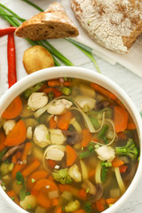 Saucepan with delicious turkey soup on table