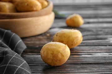 Raw organic potatoes on wooden table