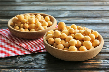 Bowls with raw organic potato on wooden table
