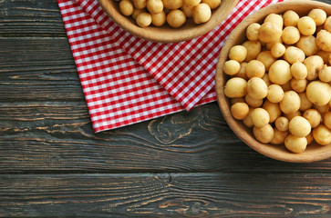 Bowl with raw organic potato on wooden table