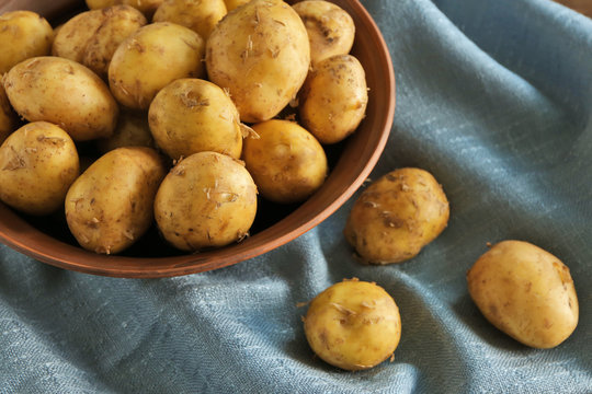 Bowl with raw organic potato on napkin