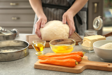 Woman kneading dough for carrot cake in kitchen