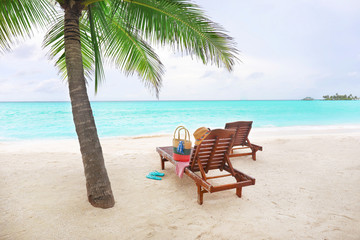 Fototapeta na wymiar Sun loungers with beach accessories at tropical resort