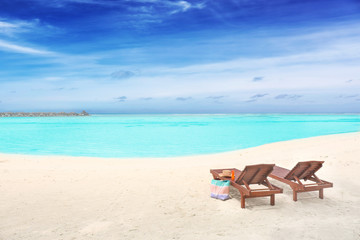 Fototapeta na wymiar Wooden sun loungers with beach accessories at sea resort