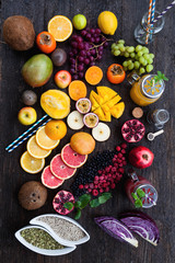 Fototapeta na wymiar Fruits and frozen berries on dark rustic wooden table. Purple and yellow smoothie bowl formula. Clean eating concept. Various green and red veggies, fruit and superfoods ready to prepare smoothie bowl