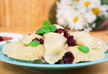 Delicious dumplings with cherry on wooden background