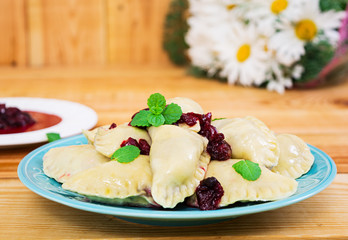 Delicious dumplings with cherry on wooden background