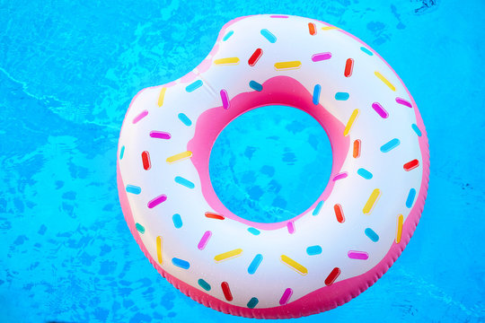 Inflatable colorful donut in blue swimming pool