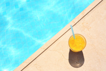 Tasty refreshing cocktail on edge of swimming pool