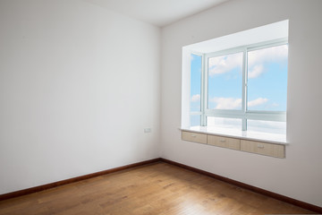 Light empty room with big white isolated window and wooden floor