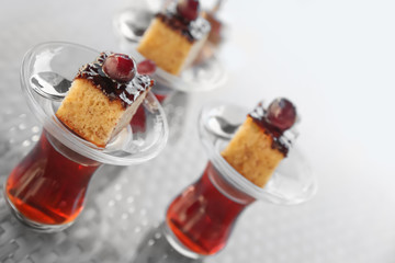 Turkish tea in traditional glasses with desserts on table
