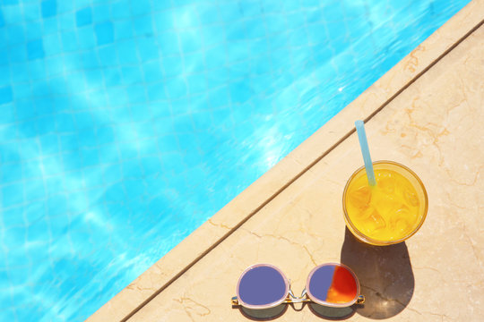 Tasty Refreshing Cocktail With Sunglasses On Edge Of Swimming Pool