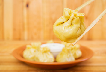 Delicious manti dumplings on wooden background