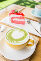 green tea milk latte cup on wood table in coffee shop