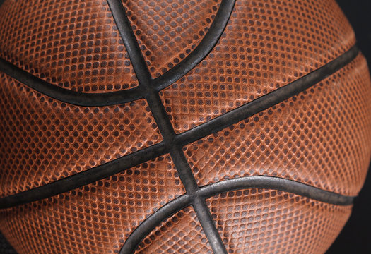 Old basketball ball on black background closeup