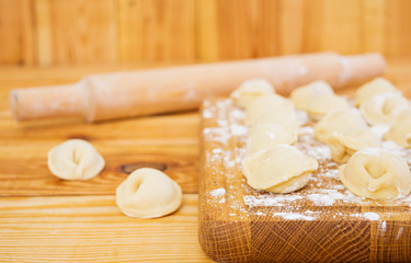 Meat dumplings, ravioli, on wooden background