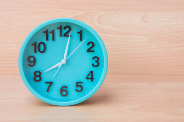 Green clock on wood background , Clock to tell time Create a plan to manage the hustle of life or work.