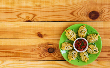 Obraz na płótnie Canvas Delicious manti dumplings on wooden background