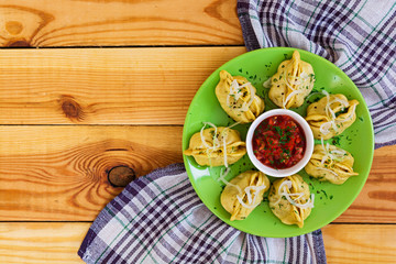 Delicious manti dumplings on wooden background