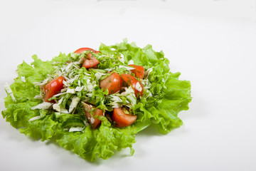 Salad of cucumbers, tomatoes and cabbage on a white background