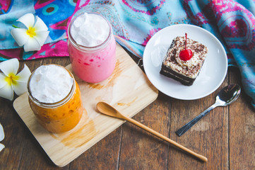 thai tea milkshake and pink milkshake beverage and cake chocolate dessert on wood table