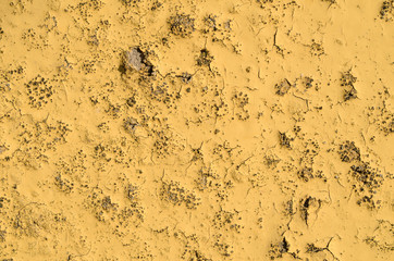 The texture of the yellow old paint on the concrete