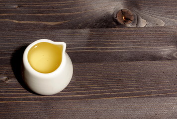 Vegetable oil in a cup on a wooden table