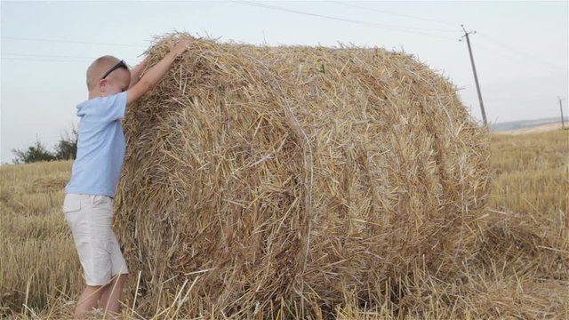Boy playing on a straw field/The boy is on the march to jump on the straw of the straw
