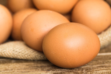 chicken eggs in brown gunny sack on wooden table ,close up