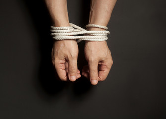 Male hands bound with rope