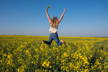 Joyful young woman jumping in field