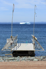 Fototapeta na wymiar Old wharf and iceberg , Trinity Bay, Newfoundland, Canada.