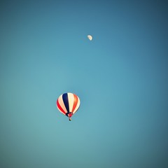 Colorful hot air balloon flying at sunset. Natural colorful background with sky and moon.