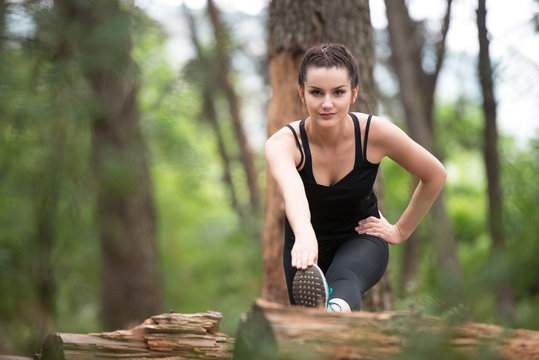 Fitness Woman Stretching In Wooded Forest Area