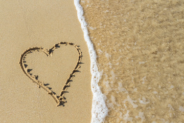 Heart drawn in the sand. Beach background. Top view